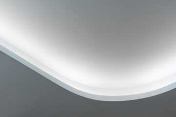 Rounded corner of the white walls and drywall suspended ceiling with integrated LED lighting