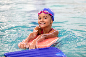 Portrait of little smiling girl in swimming pool