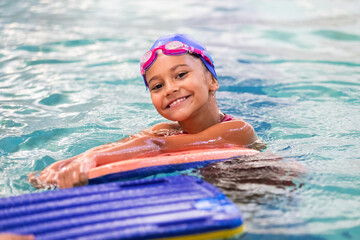 Portrait of little smiling girl in swimming pool