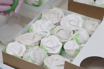 Homemade marshmallows in craft boxes for a gift. Zephyr in the form of roses. Close-up shot.