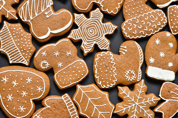 Background with homemade christmas gingerbread cookies on black. Different forms of sweet food. 