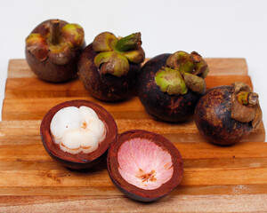 Obraz premium Mangosteen is a tropical fruit from Asia. Mangosteen has a distinctive sweet and sour taste. Mangosteen also has a myriad of benefits, properties, and nutritional content that is useful for health.