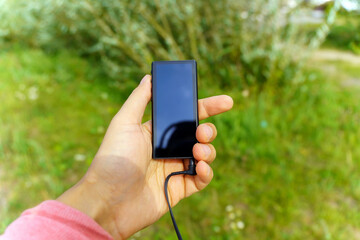 MP3 music player in the hand of a man. Listening to music in nature. Selective focus