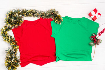 Red and green t shirt mockup with copy space and Christmas Holiday template flatlay. Top view blank t-shirt on white background. Happy New Year decorations - obrazy, fototapety, plakaty