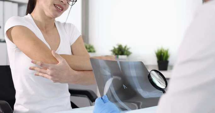 Doctor examining xray of woman sore elbow in clinic 4k movie