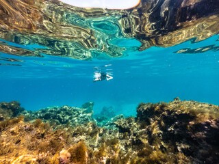 Woman snorkeling around coral reef. Underwater photo