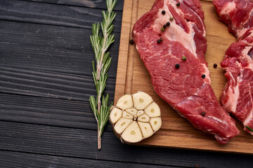 meat steak wooden board and spices ingredients top view