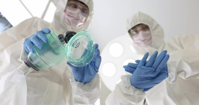 Doctors in protective suits and masks performing indirect heart massage and artificial respiration bottom view 4k movie