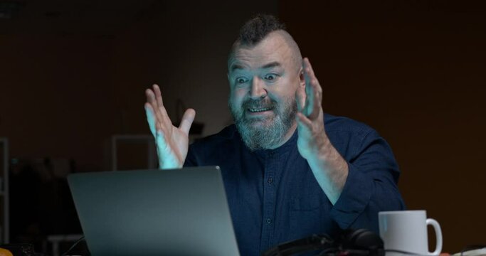 Bearded man spitefully typing on a laptop. Accelerated video. Communication on social networks.