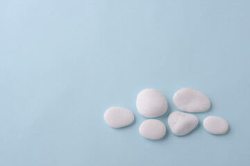 Sea pebbles on a blue background. place for text. Flat lay