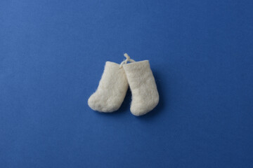 Felt boots on a blue background, top view. A festive or children's poster with Santa's boots. Felt boots in miniature. Original Christmas background