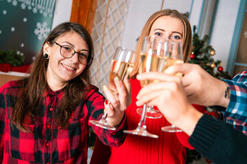 teenager party on Christmas time with drink alcohol from wine glasses and says toasts