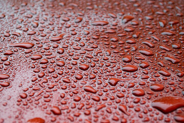 Water drops on deep red defocused background