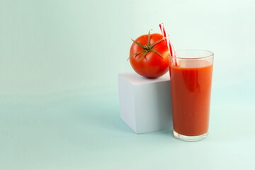 The concept of tomato juice consumption. Tomato juice and juicy tomato on a blue background place for text