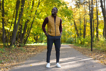 Hipster african american man walking in autumn park