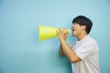 メガホンを持って叫ぶ白シャツの男性