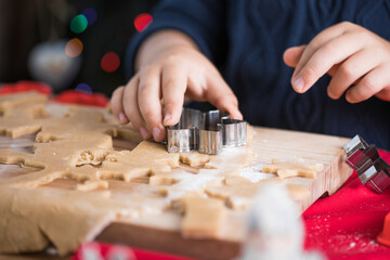 Little cute kid boy  make Christmas gingerbread cookies in the New Year's kitchen.