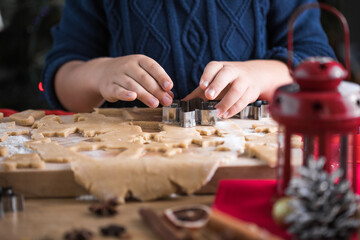 Little cute kid boy  make Christmas gingerbread cookies in the New Year's kitchen.