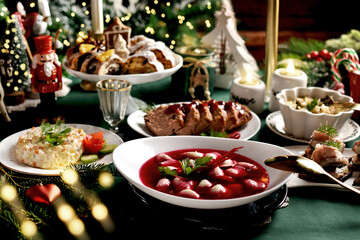 Traditional Christmas Eve dishes with red borscht and dumplings on festive table