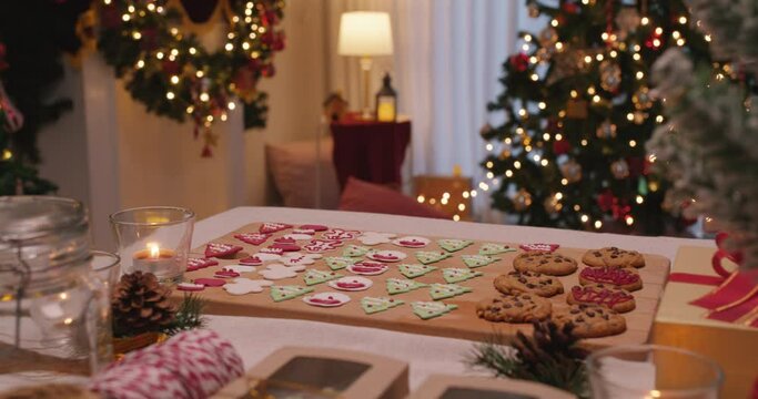 Merry Xmas eve moment with gingerman and santa claus colorful red green sugar icing snack on desk. Cute sweet food pastry dough for new year night party good warm time inside apartment house.