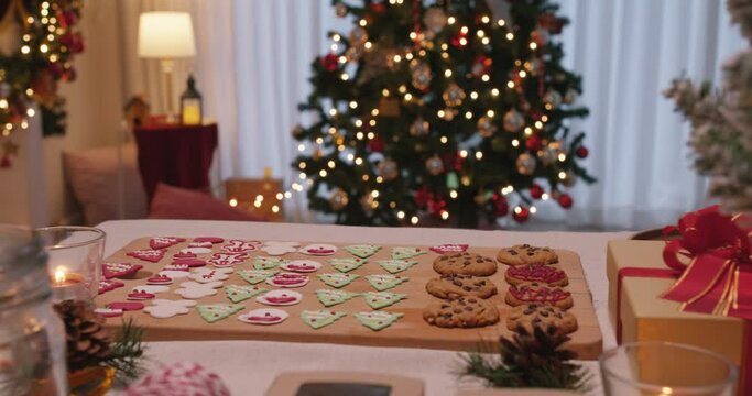 Merry Xmas eve moment with gingerman and santa claus colorful red green sugar icing snack on desk. Cute sweet food pastry dough for new year night party good warm time inside apartment house.