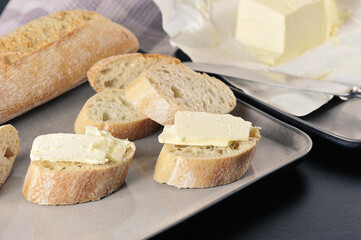 butter, knife and sliced baguette