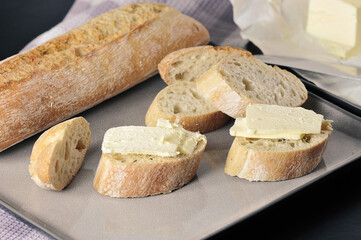 butter, knife and sliced baguette