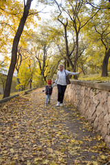 grandmother and granddaughter running around having fun in the autumn park