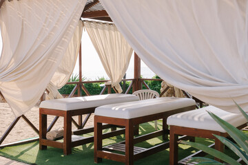 Outdoor canopy massage beds. Massage sessions on the beach. Rest and relaxation at the seaside resort.