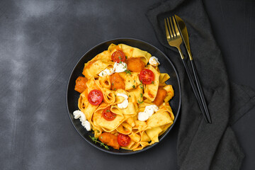 Italian  pasta pappardelle with pumpkin, tomatoes and mozzarella. vegetarian food