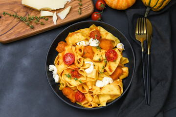 Italian  pasta pappardelle with pumpkin, tomatoes and mozzarella. vegetarian food