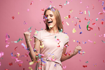 Studio shot of successful young woman celebrating achievement with confetti - obrazy, fototapety, plakaty