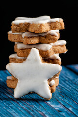 Stack of cinnamon stars on blue background. Close up.