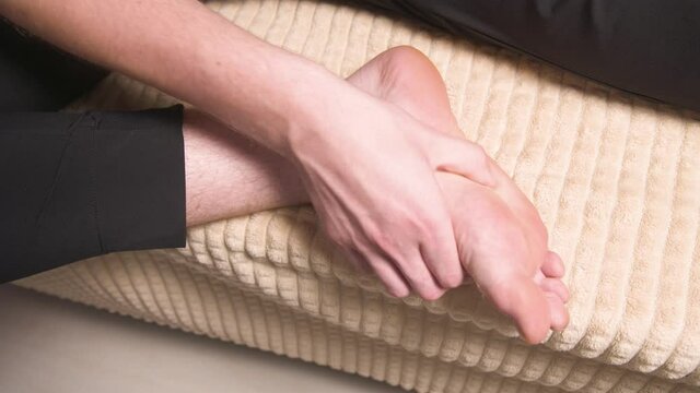 Close-up of self-massage feet. a man massages his foot. prevention of flat feet