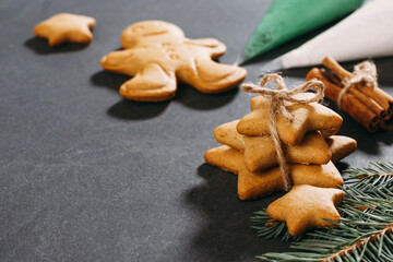 Christmas gingerbread cookies ready to decorate with icing, aromatic cloves, ginger, cinnamon and rich black treacle. Close-up on the table. Stars and gingerbread man. Kids activity. Copy space, card