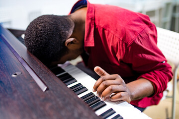 upset african american handsome musician man discontent singing, and teaching to play on piano