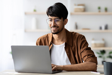 Happy middle eastern man employee working at office