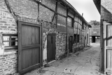 Black and white photo of an old farmhouse with wooden beams in the masonry in the province of Limburg, the Netherlands