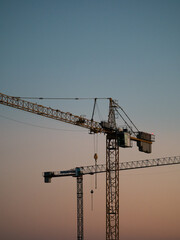 Fototapeta premium Construction cranes on a newly built housing estate