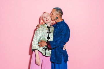 Young white man in chinese jacket hugging and kissing her girlfriend