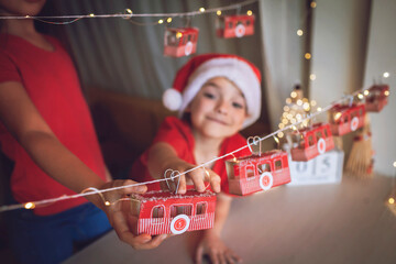 Happy kid opens crafted advent calendar on theme of skis and cable car. Ski resort funicular of...