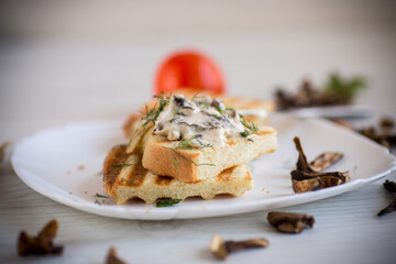 fried bread toast with cheese spread with boiled dried mushrooms on a wooden table.