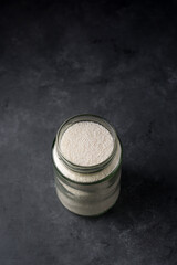 jar of sago balls or tapioca pearls isolated on a dark textured background, taken from above with copy space