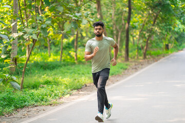 Young man running in the park at morning, also known as jogging or morning walk