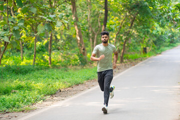 Young man running in the park at morning, also known as jogging or morning walk