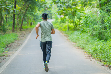 Obraz premium Young man running in the park at morning, also known as jogging or morning walk
