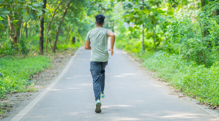 Young man running in the park at morning, also known as jogging or morning walk