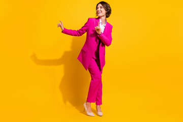 Photo of charming funky young woman dressed pink suit dancing smiling isolated yellow color background