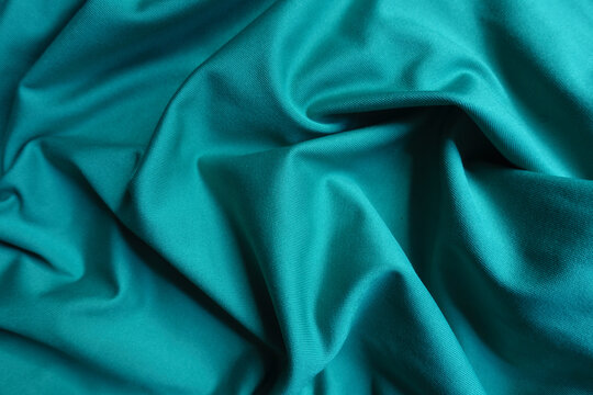 Background - blue green polyester fabric in soft folds