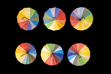 Obraz premium Six multi-coloured sun umbrellas on a black background.